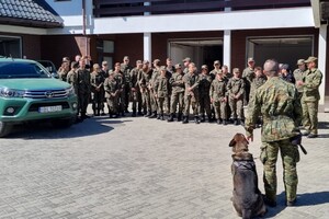 grupa uczniów oraz funkcjonariusz SG wraz z psem służbowym