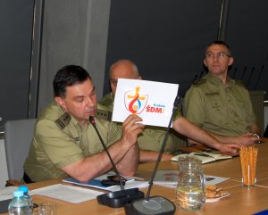 Zastępca Komendanta BiOSG płk SG Robert Rogoz przedstawia logo ŚDM, którym winne być oznakowane pojazdy z pielgrzymami 